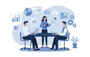Three colleagues sit around a conference table with laptops while a woman presents a chart.