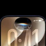 ios-27 – mobile marketing reads Close-up of a dark-framed smartphone screen showing a curved edge and a large gold '0:41' time overlay near the center top, with the notch and dual front camera at the top.