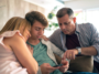 meta-australia-teen-account-removals – mobile marketing reads Three adults on a sofa, huddled together and looking at a smartphone.